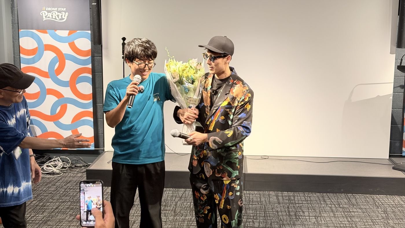 ステージで、パーソナリティの2人が花束を受け取る場面