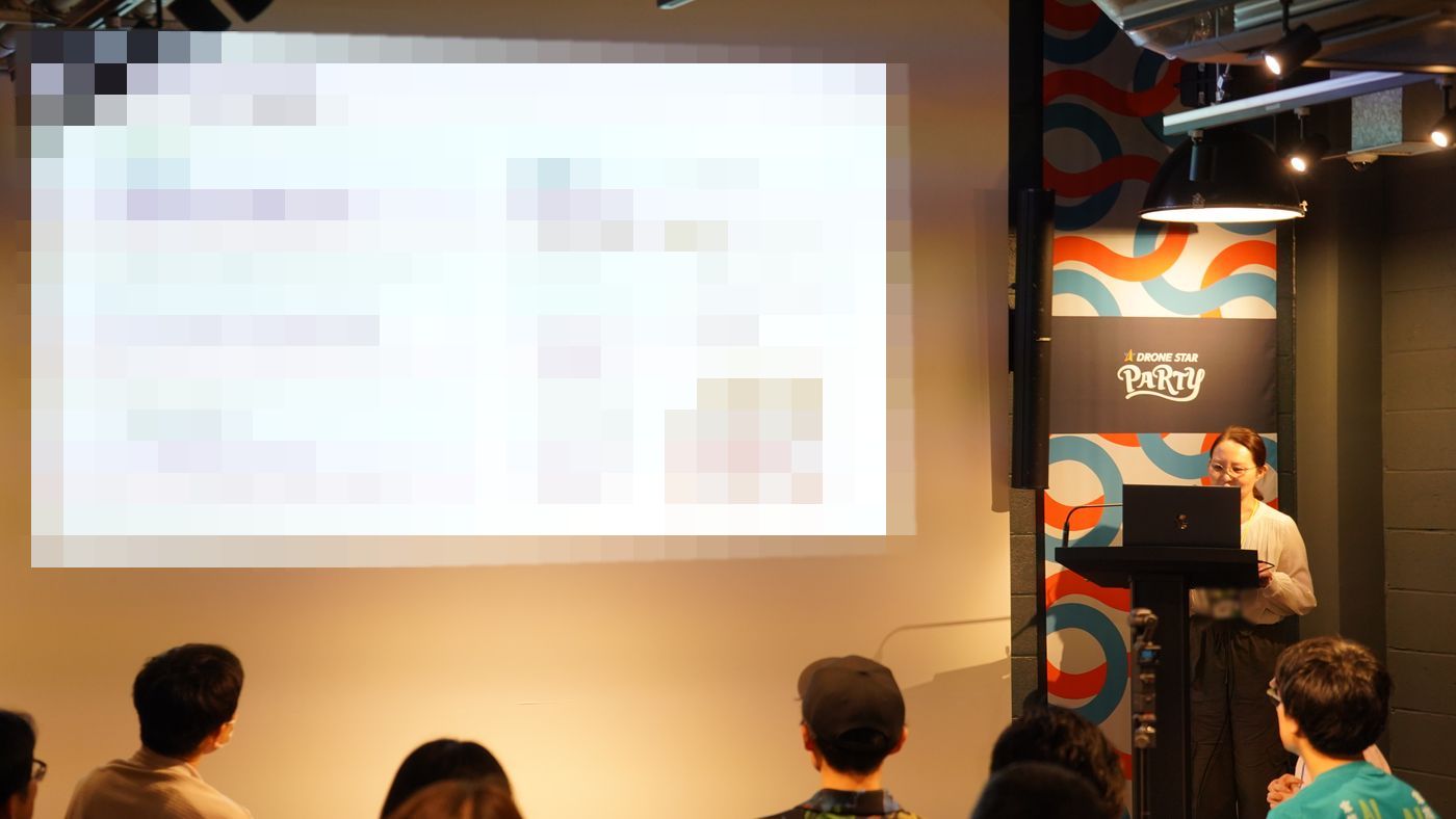 演台のパソコンを操作しながら発表する登壇者